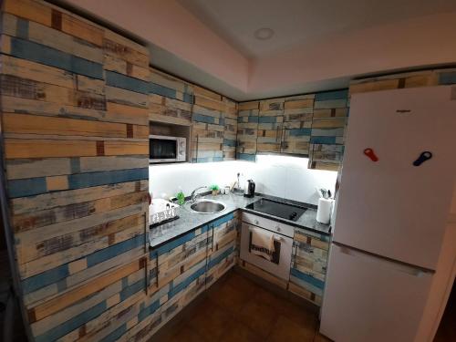 cocina con nevera blanca y fregadero en Apartamentos Parke24 - San Sebastian en Rentería