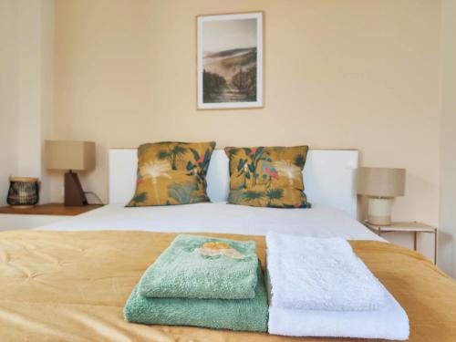 a bedroom with a bed with two towels on it at Le rêve d'Alice in Saint-Puy