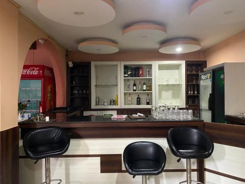 a bar with black leather stools in a restaurant at Hotel Gorkha Palace Pvt. Ltd in Gorkhā