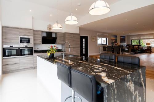 a kitchen with a large marble counter top and black chairs at No. 7 Glamaig Place in Portree