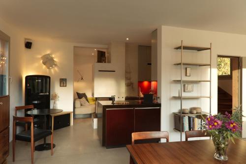 a kitchen and a living room with a table and chairs at Hausteil in einer Waldlichtung im Stadtwald in Zurich