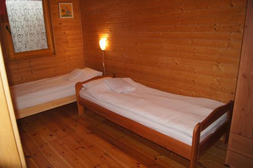 a room with two beds in a wooden cabin at Domek letniskowy Barakuda in Chałupy