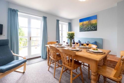 a dining room with a wooden table and chairs at 4 Crespigny House - Aldeburgh Coastal Cottages in Aldeburgh