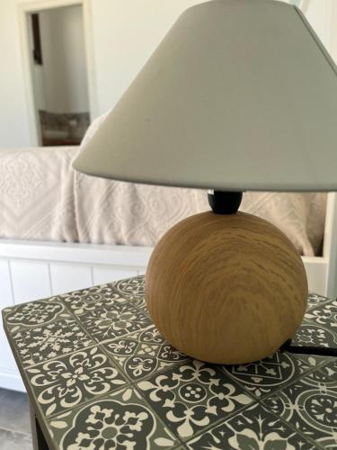 a lamp sitting on top of a table with a bed at MANZIL Country House in Valderice