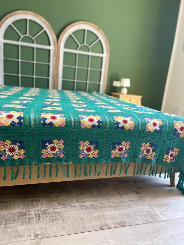 a bed with a quilt on it in a room at MANZIL Country House in Valderice