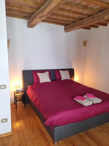 a bedroom with a bed with a red bedspread at Podere Vecci in Dicomano