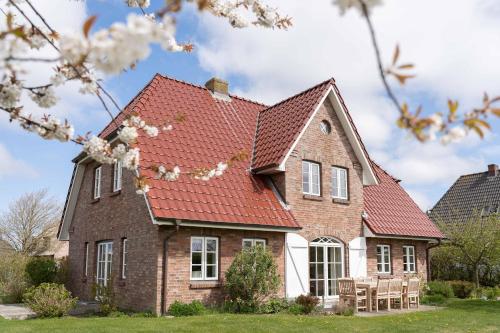 a brick house with a red roof at Antonias Hüs in Midlum