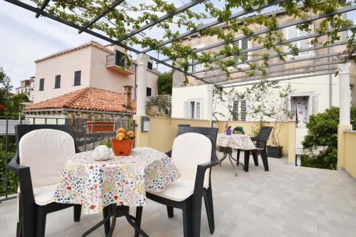 un patio con mesas, sillas y una pérgola en Guesthouse Manda, en Dubrovnik