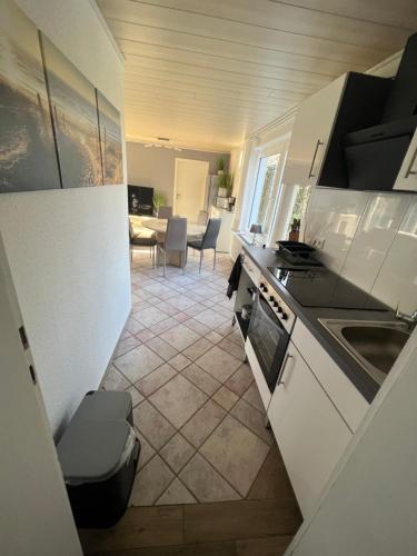 a kitchen with white cabinets and a tile floor at Achtern Diek in Lembruch