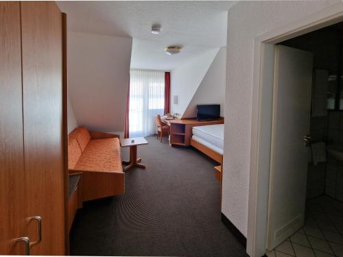 a hotel room with a bed and a desk at Hotel Gerberhof in Backnang
