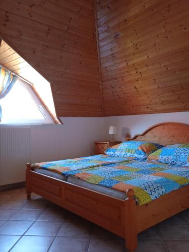 a bed in a room with a wooden ceiling at Balaton White House in Vonyarcvashegy