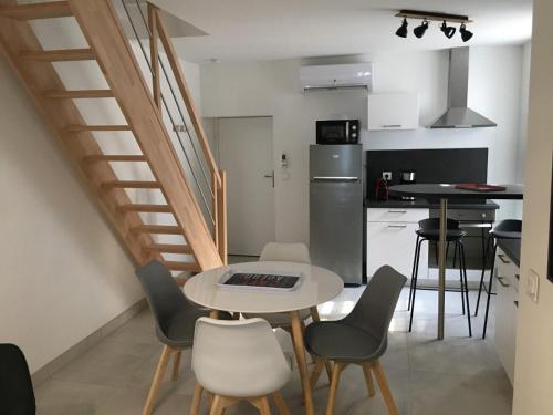 cocina y comedor con mesa y sillas en Gîte La Fontaine en Mer