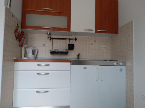 una cocina con armarios blancos y fregadero en Apartments Renko, en Stari Grad