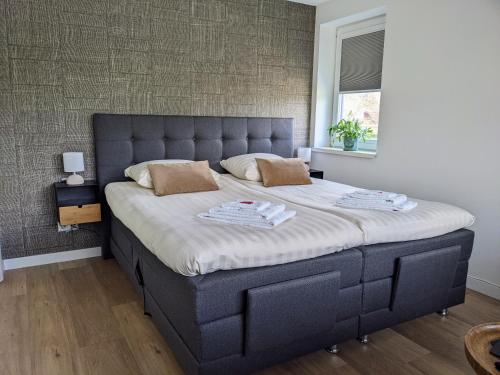a bedroom with a large bed with a blue headboard at Bed&Bubbels 256 in De Koog
