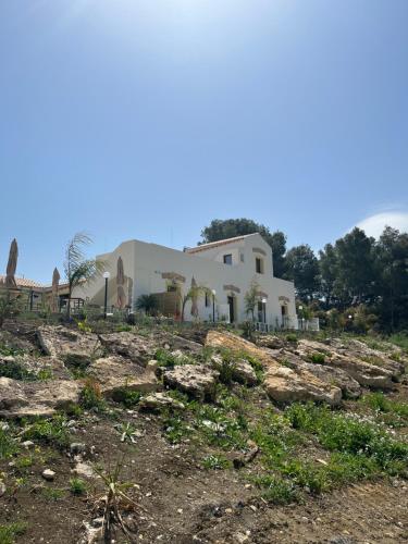 una casa sentada en la cima de un campo rocoso en MANZIL Country House, en Valderice