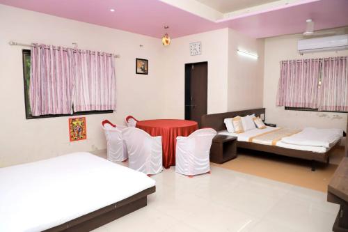 Habitación con 2 camas, mesa y sillas en Hotel Annapura Residency, Chalisgaon, en Chālisgaon