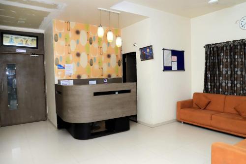 a waiting room with a couch and a desk at Hotel Annapura Residency, Chalisgaon in Chālisgaon