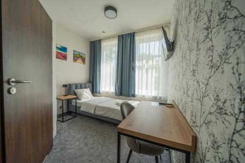 a hotel room with a bed and a table at Kelman Inn Global Nowa Sól in Nowa Sól