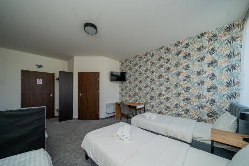 a hotel room with two beds and a tv at Kelman Inn Global Nowa Sól in Nowa Sól