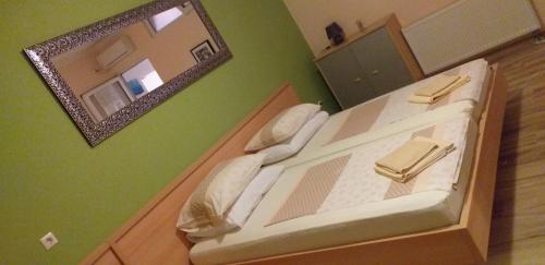 a large bed with a mirror on a green wall at Apartments Villa Bella Vista Hvar in Hvar