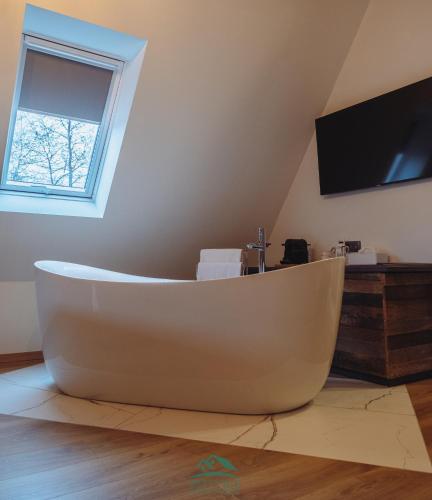 a large white bath tub in a room with a tv at B&B Plitvice Holiday Lodge in Plitvička Jezera