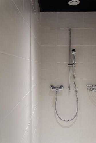 a bathroom with a shower in a white wall at Campra Alpine Lodge & Spa in Olivone