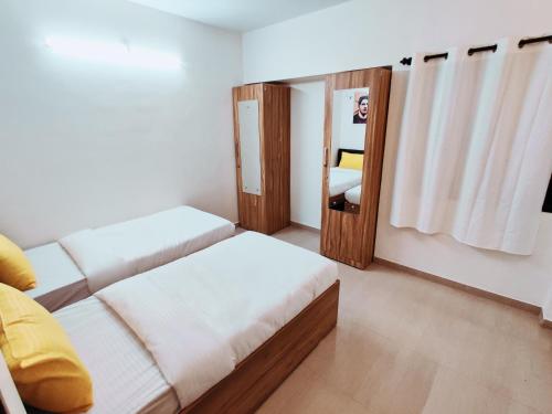 a small room with a bed and a mirror at Procida Hostel by Zero Jhanjhat in Pune