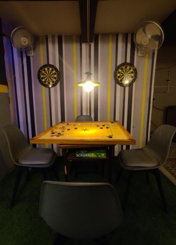 a table and chairs in a room with a striped wall at Procida Hostel by Vibe Village in Pune