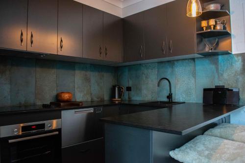 a kitchen with brown cabinets and a counter top at The Nest - A High Altitude Hideaway in Crackenback