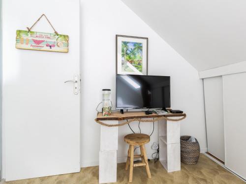 a room with a desk with a television and a stool at Les rayonnantes in La Roche-Maurice