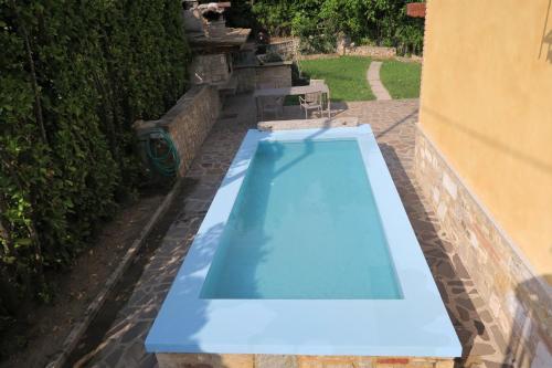 a blue swimming pool in a yard next to a building at Villa Arianna - Apartments with lake view, pool, garten, privacy, parking, close to city center in Tignale