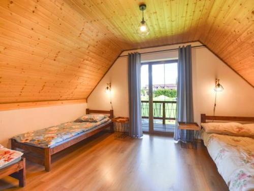 a attic room with two beds and a window at Domki U Tadzia 603-425-844 in Polańczyk
