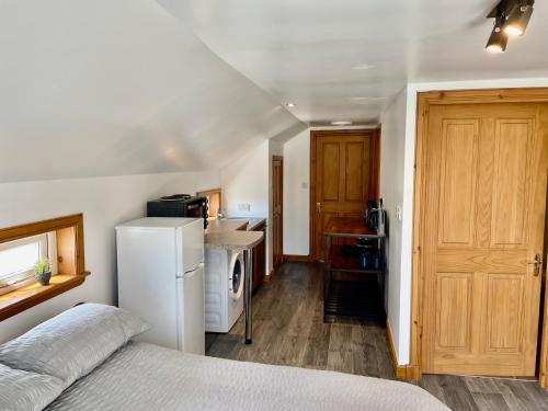 Cette chambre comprend une petite cuisine avec un réfrigérateur blanc. dans l'établissement Holmview apartment, à Stornoway