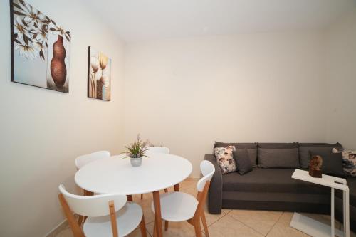 a living room with a white table and a couch at Angels Pool Studios and Apartments in Paleokastritsa