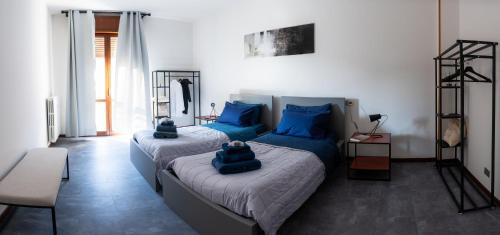 een slaapkamer met twee bedden met blauwe kussens erop bij URBAN B. in Bologna