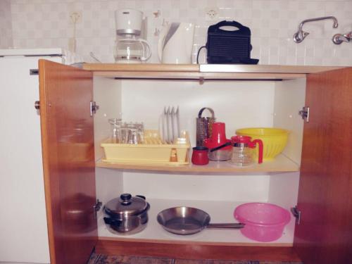 a kitchen cabinet filled with lots of kitchen utensils at Studios Crete in Ferma