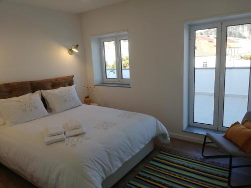 una camera da letto con un letto e due asciugamani di Da' Vila - Alojamento Local a Ponte de Lima