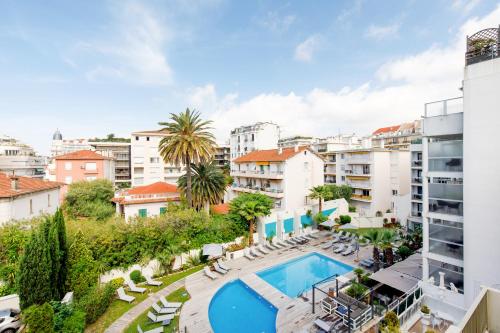 un appartement avec une piscine et des bâtiments dans l'établissement Bleu Croisette YourHostHelper, à Cannes