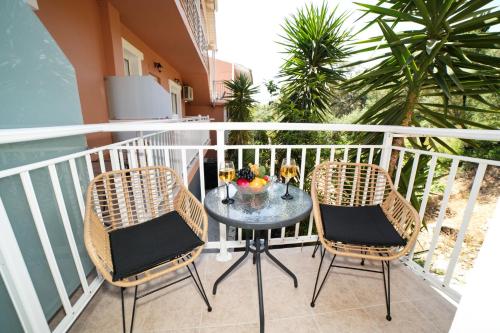 a balcony with a table and two chairs at Angels Pool Studios and Apartments in Paleokastritsa