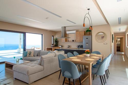 a living room with a couch and a table and chairs at Lamar Private Luxury Villas in Marathias