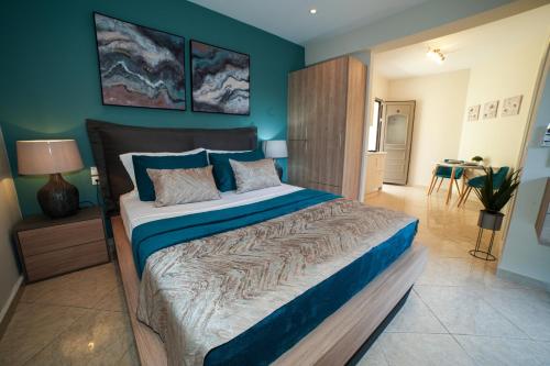a bedroom with a large bed with blue walls at Angels Pool Studios and Apartments in Paleokastritsa