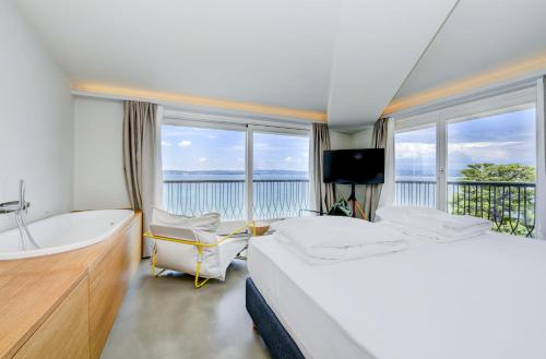 um quarto com uma banheira, uma cama, uma banheira e uma televisão em Hotel Flaminia em Sirmione