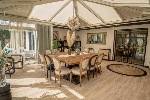 Un comedor con mesa y sillas en La Parenthèse du Las, Maison d'hôtes avec Piscine et Spa, en Saint-Jean-dʼIllac