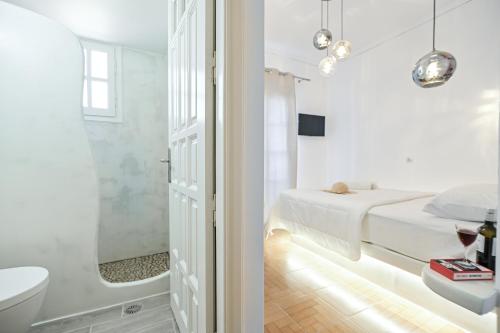 a white bathroom with a bed and a bath tub at Katy's Home in Naxos Chora