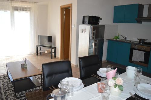 a kitchen and dining room with a table and chairs at Central Apartments Preko in Preko