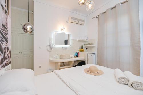 a small white bedroom with a sink and a bed at Katy's Home in Naxos Chora