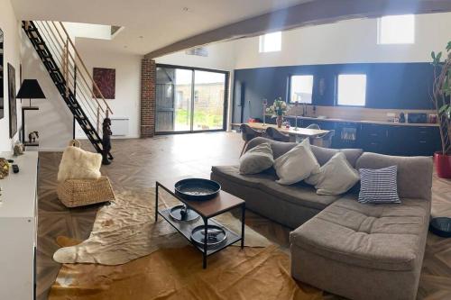 a living room with a couch and a table at Gîte dans un Haras in Émanville