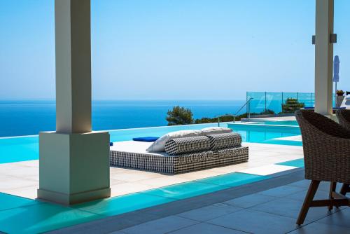 a bed on a patio next to a swimming pool at Lamar Private Luxury Villas in Marathias