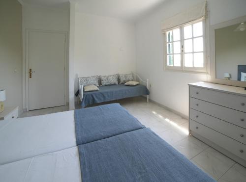 a bedroom with a bed and a dresser and a window at Angels Pool Studios and Apartments in Paleokastritsa