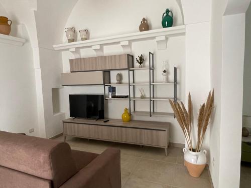 a living room with a couch and a tv at Calce Bianca in Tuglie